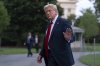 U.S. President Donald Trump waves to reporters as he walks on the South Lawn upon arriving at the White House, Sunday, July 13, 2025, in Washington. (AP Photo/Jose Luis Magana)