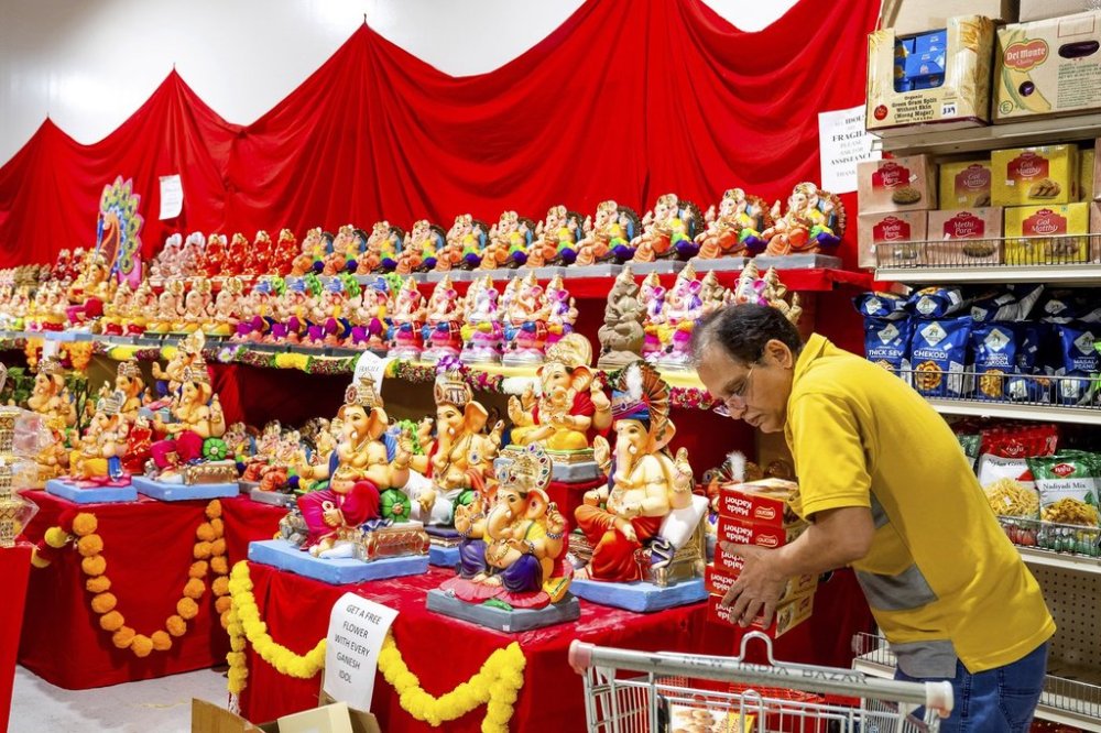 A worker stocks products at New India Bazar, where most merchandise is imported from India and Canada, on Wednesday, Aug. 6, 2025, in Fremont, Calif. (AP Photo/Noah Berger)