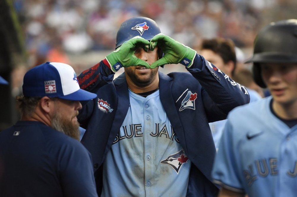 Toronto Blue Jays' George Springer, center, reacts after hitting a home run during the ninth inning of a baseball game against the Detroit Tigers, Saturday, July 26, 2025, in Detroit. (AP Photo/Jose Juarez)