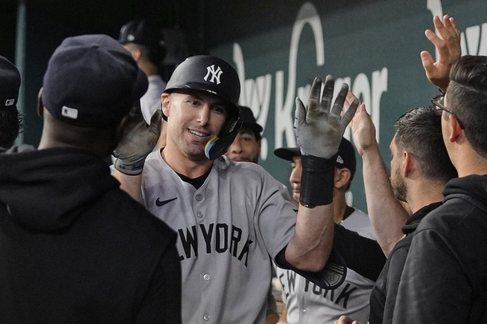 New York Yankees' Paul Goldschmidt, center, celebrates with the team after hitting a solo home run in the seventh inning of a baseball game against the Texas Rangers Wednesday, Aug. 6, 2025, in Arlington, Texas. (AP Photo/Tony Gutierrez)