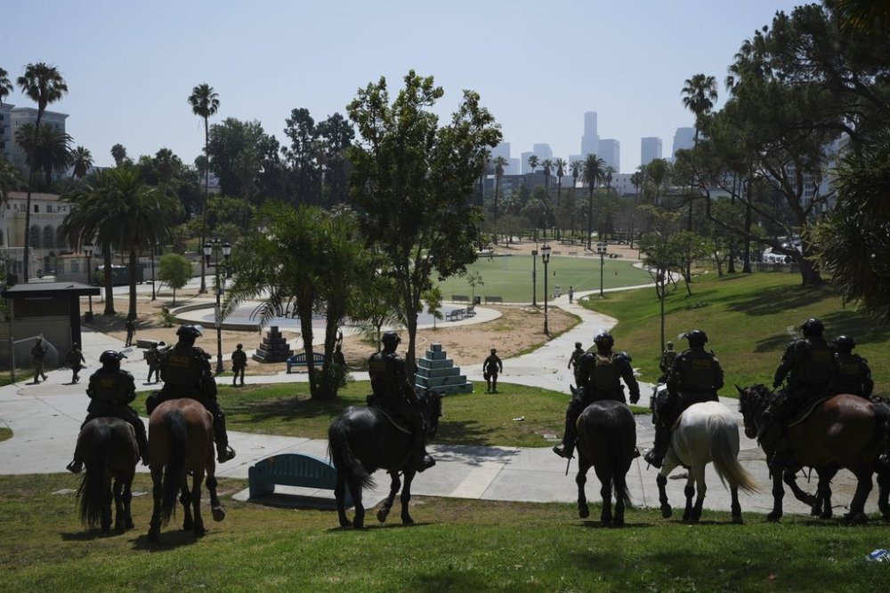 FILE - Federal agents ride on horseback at MacArthur Park Monday, July 7, 2025, in Los Angeles. (AP Photo/Damian Dovarganes,File)