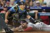 Washington Nationals' Dylan Crews, bottom, scores past Philadelphia Phillies catcher J.T. Realmuto on a single by Daylen Lile during the ninth inning of a baseball game Friday, Aug. 22, 2025, in Philadelphia. (AP Photo/Matt Slocum)