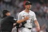 Home plate umpire Phil Cuzzi, left, holds back Colorado Rockies starting pitcher Kyle Freeland as he yells at San Francisco Giants' Rafael Devers after his two-run home run in the first inning of a baseball game Tuesday, Sept. 2, 2025, in Denver. (AP Photo/David Zalubowski)