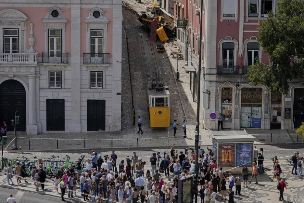People look at a tourist streetcar derailed and crashed in Lisbon, Portugal, Thursday, Sept. 4, 2025. (AP Photo/Armando Franca)