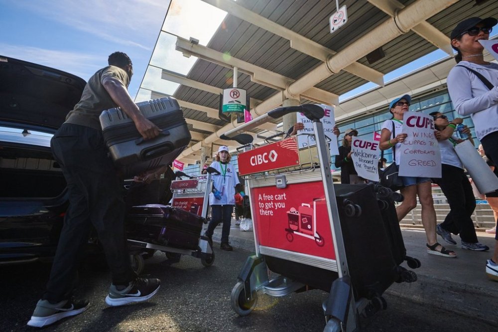 Travellers pass Air Canada flight attendants on strike at Pearson International Airport in Toronto, on Monday, Aug. 18, 2025. THE CANADIAN PRESS/Sammy Kogan