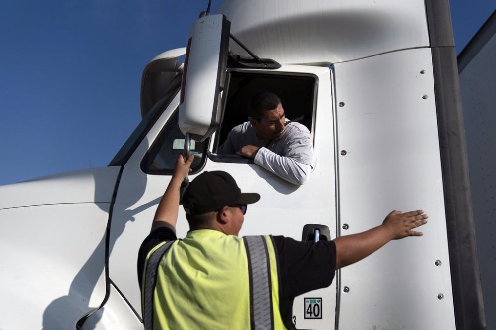 FILE - Senior instructor Markus Juarez, bottom, talks to student driver Jaime Rojas at California Truck Driving Academy in Inglewood, Calif., Wednesday, Nov. 17, 2021. (AP Photo/Jae C. Hong, File)