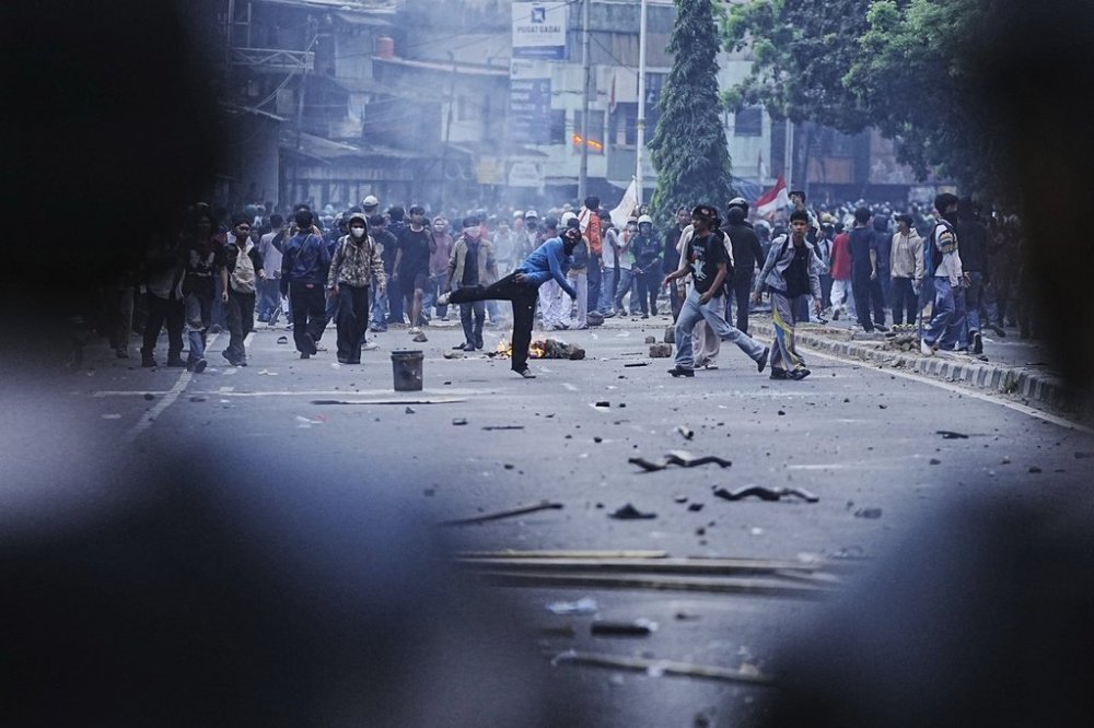 Protesters throw rocks towards riot police during a protest against lavish allowances given to parliament members, in Jakarta, Indonesia, Monday, Aug. 25, 2025. (AP Photo/Achmad Ibrahim)