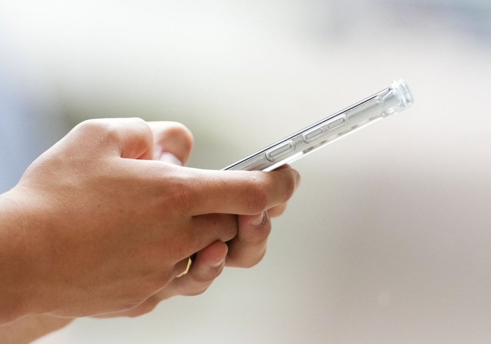 Researchers say that as AI chatbots become more commonplace, companies must find ways to alleviate concerns about trust, while balancing them with old-fashioned human-to-human conversations. A person uses a cellphone in Ottawa on Monday, July 18, 2022. THE CANADIAN PRESS/Sean Kilpatrick