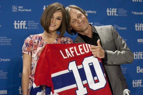 Viggo Mortensen and Keira Knightley hold up a Montreal Canadiens hockey shirt as they promote the film 