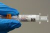 A pharmacist holds a Pfizer and BioNTech COVID-19 vaccine shot on Thursday, April 24, 2025, in Portland, Ore. (AP Photo/Jenny Kane, File)