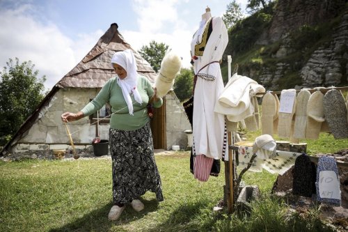 A Bosnian Muslim woman prepares wool that she later knits into sweaters or socks and sells to tourists in Umoljani village on Bjelasnica mountain near Sarajevo, Bosnia, Tuesday, Aug. 5, 2025. (AP Photo/Armin Durgut)