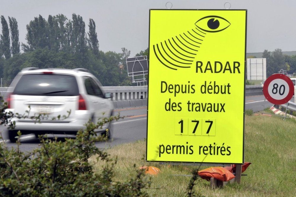 FILE - A vehicle passes in front of a sign of the Vaud Cantonal Police indicating the number of driving licences withdrawn for speeding in the construction zone on the A1 motorway between Lausanne and Yverdon, Switzerland, Tuesday, June 15, 2010. (Dominic Favre/Keystone via AP, file)