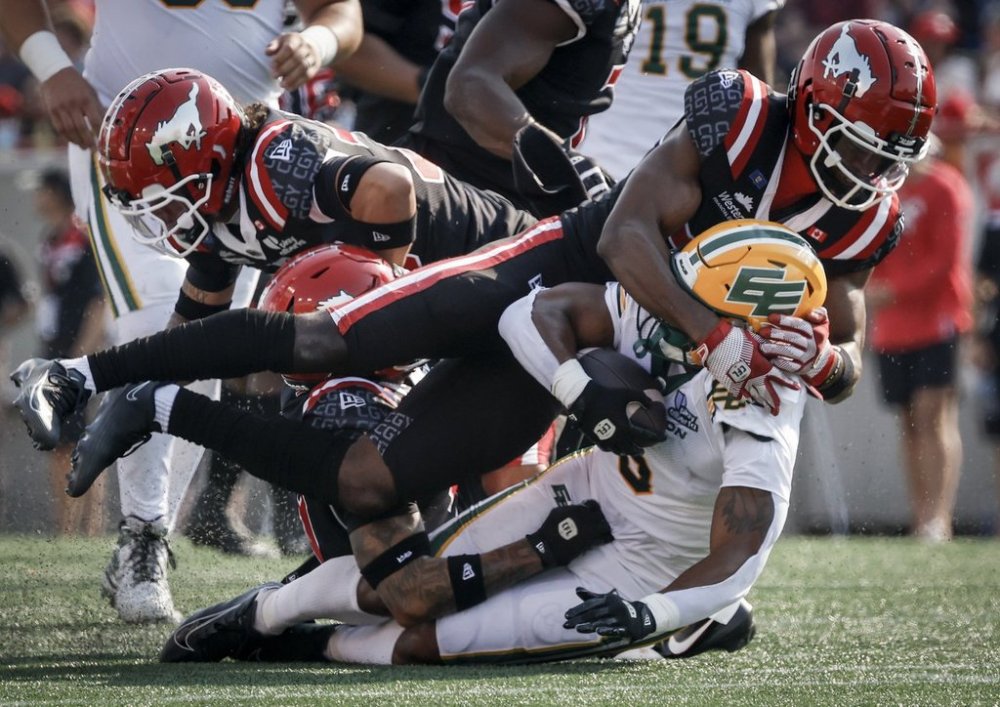 Edmonton Elks' Justin Rankin, bottom, is tackled by Calgary Stampeders' Godfrey Onyeka during first half CFL football action in Calgary, Alta., Monday, Sept. 1, 2025. THE CANADIAN PRESS/Jeff McIntosh