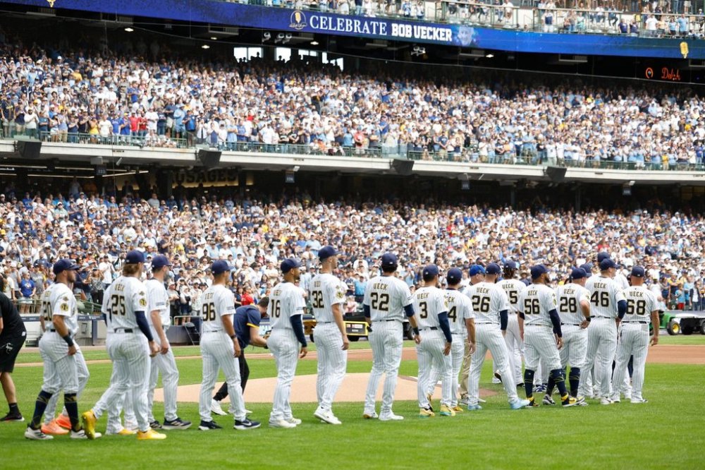 Milwaukee Brewers players walk onto the field for the ceremonial first pitch during the Bob Uecker Celebration of Life before a baseball game against the San Francisco Giants, Sunday, Aug. 24, 2025, in Milwaukee. (AP Photo/Jeffrey Phelps)