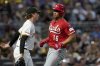 Cincinnati Reds' Noelvi Marte, right, scores next to Pittsburgh Pirates pitcher Ryan Borucki, left, during the seventh inning of a baseball game Saturday, Aug. 9, 2025, in Pittsburgh. (AP Photo/Matt Freed)
