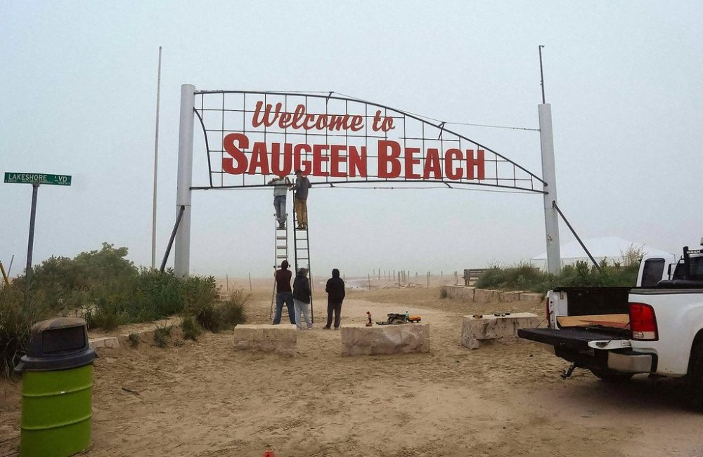 Saugeen First Nation members work on changing the lettering of the former Sauble Beach welcome sign, updated to reflect the reallocation of the land to the First Nations community, on Tuesday, July 1, 2025. THE CANADIAN PRESS/Handout - Cheree Urscheler (Mandatory Credit)