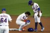 New York Mets' Francisco Alvarez, center, is tend to by first base coach Antoan Richardson (66) and manager Carlos Mendoza after being injured sliding into second during the seventh inning of the Little League Classic baseball game against the Seattle Mariners at Bowman Field in Williamsport, Pa., Sunday, Aug. 17, 2025. (AP Photo/Gene J. Puskar)