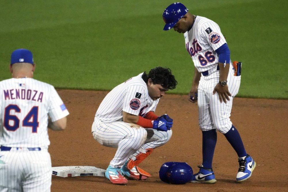 New York Mets' Francisco Alvarez, center, is tend to by first base coach Antoan Richardson (66) and manager Carlos Mendoza after being injured sliding into second during the seventh inning of the Little League Classic baseball game against the Seattle Mariners at Bowman Field in Williamsport, Pa., Sunday, Aug. 17, 2025. (AP Photo/Gene J. Puskar)