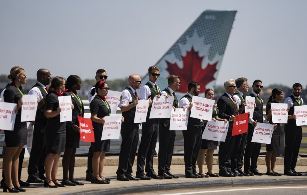 Air Canada flight attendants hold a silent protest at Montreal-Pierre Elliott Trudeau International Airport in Montreal on Monday, Aug. 11, 2025. THE CANADIAN PRESS/Christinne Muschi