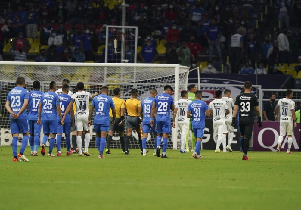 FILE - Players of Mexico's Cruz Azul and Monterrey leave the pitch after referee suspended the game for ten minutes because of homophobic chants during a CONCACAF Champions League semifinal second leg soccer match at Azteca stadium in Mexico City, Thursday, Sept. 16, 2021. (AP Photo/Fernando Llano, File)