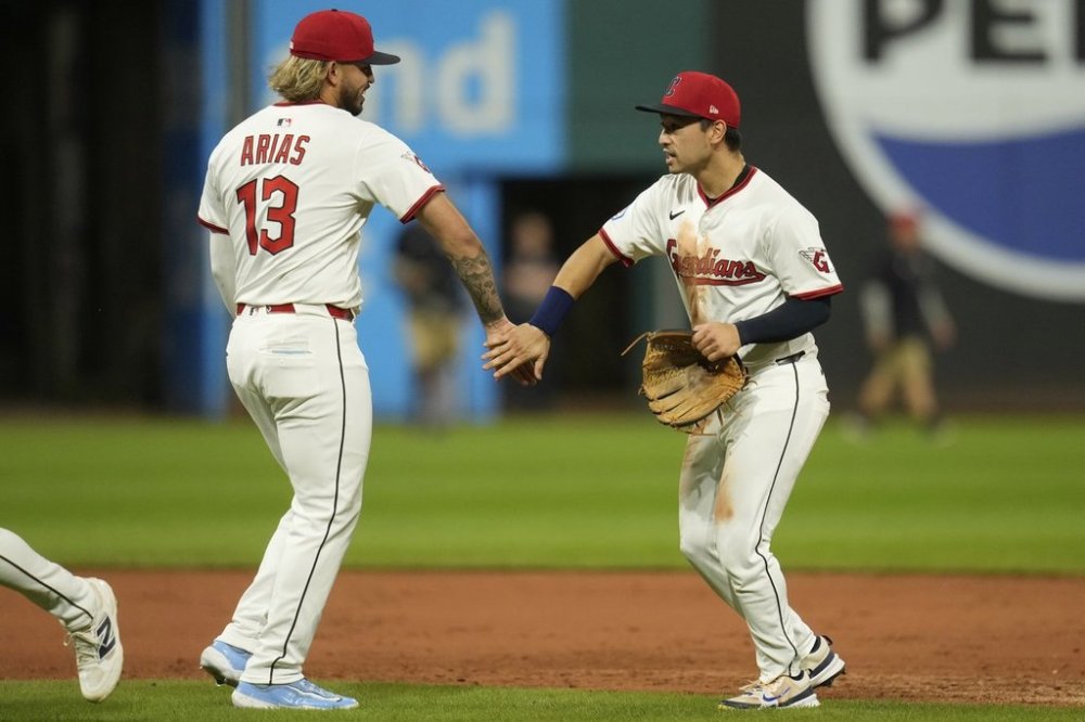 Cleveland Guardians shortstop Gabriel Arias (13) and left fielder Steven Kwan, right, celebrate after the Guardians defeated the Tampa Bay Rays in a baseball game in Cleveland, Tuesday, Aug. 26, 2025. (AP Photo/Sue Ogrocki)