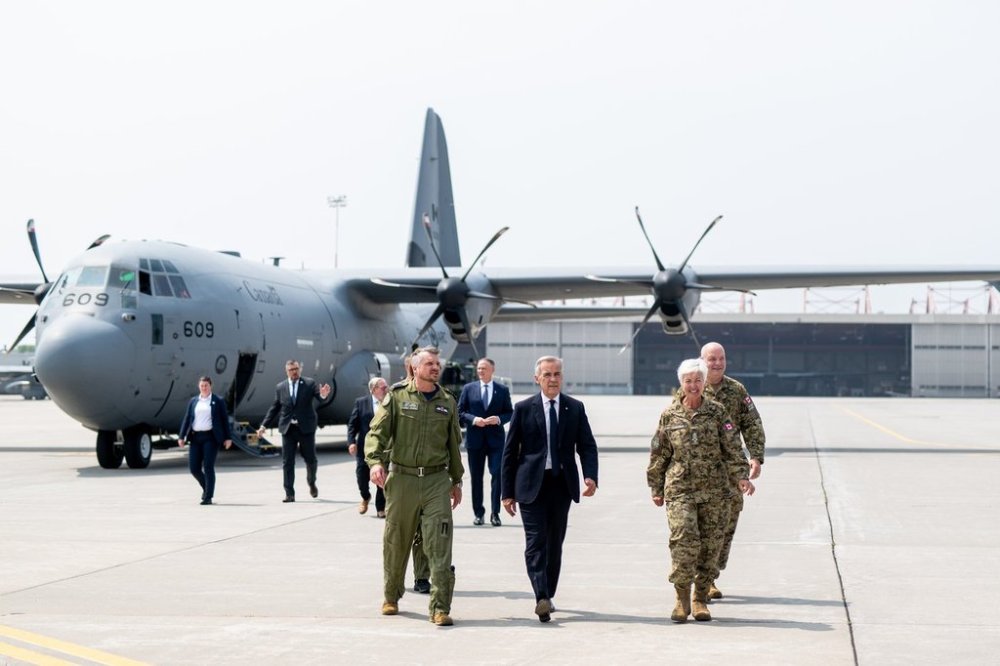 Prime Minister Mark Carney, centre, and Chief of the Defence Staff Gen. Jennie Carignan, right, walk on the tarmac of Canadian Forces Base (CFB) 8 Wing Trenton in Trenton Ont., on Friday, Aug. 8, 2025. THE CANADIAN PRESS/Spencer Colby