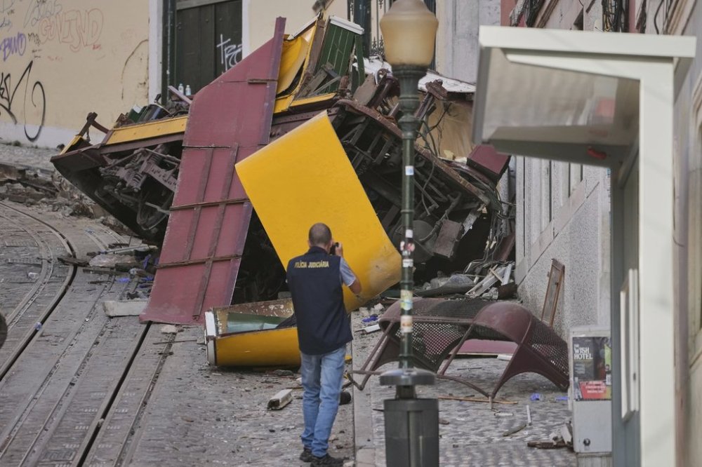 Police officers inspect the site where a tourist streetcar derailed and crashed in Lisbon, Portugal on Thursday, Sept. 4, 2025. (AP Photo/Armando Franca)