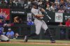 New York Yankees' Giancarlo Stanton, right, hits a home run that also scored teammate Paul Goldschmidt in front of Texas Rangers catcher Jonah Heim, left, during the fourth inning of a baseball game, Monday, Aug. 4, 2025, in Arlington, Texas. (AP Photo/LM Otero)
