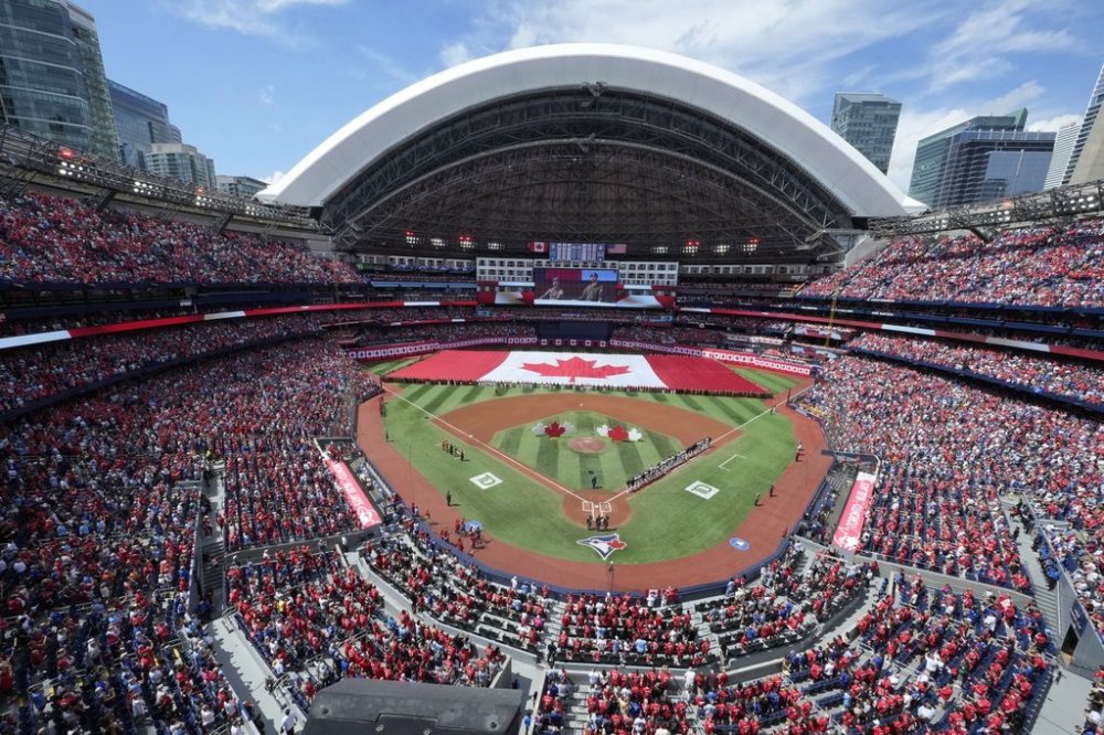 A large Canadian flag is unfurled before the start of the MLB game between the New York Yankees and the Toronto Blue Jays at Rogers Centre on Canada Day, Tuesday, July 1, 2025. THE CANADIAN PRESS/Frank Gunn