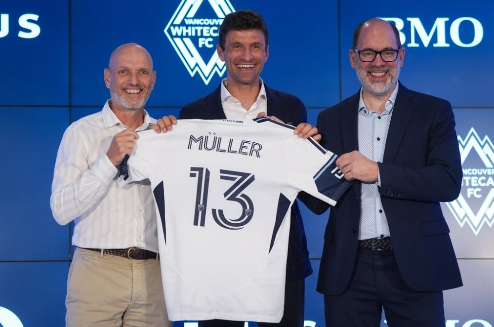 New Vancouver Whitecaps player Thomas Muller, centre, poses for photos with head coach Jesper Sorensen, left, and Whitecaps CEO and sporting director Axel Schuster, right, during a news conference in Vancouver, on Thursday, Aug. 14, 2025. The MLS soccer club signed the 2014 World Cup champion and longtime Bayern Munich star to their roster last week in a deal that also includes a designated player option for the 2026 campaign. THE CANADIAN PRESS/Darryl Dyck
