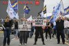 Air Canada employees and union members protest outside the Air Canada headquarters in Montreal, Sunday, Aug. 17, 2025, after the federal government intervened in the labour dispute between the airline and the union representing its flight attendants, ordering binding arbitration and operations to resume. THE CANADIAN PRESS/Graham Hughes