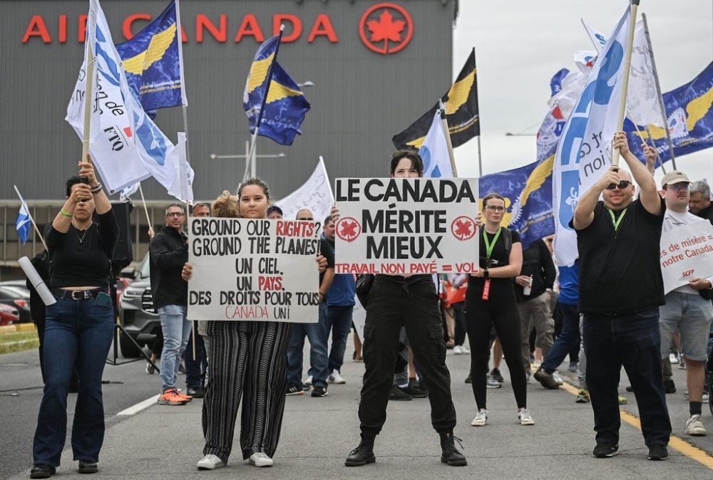 Air Canada employees and union members protest outside the Air Canada headquarters in Montreal, Sunday, Aug. 17, 2025, after the federal government intervened in the labour dispute between the airline and the union representing its flight attendants, ordering binding arbitration and operations to resume. THE CANADIAN PRESS/Graham Hughes