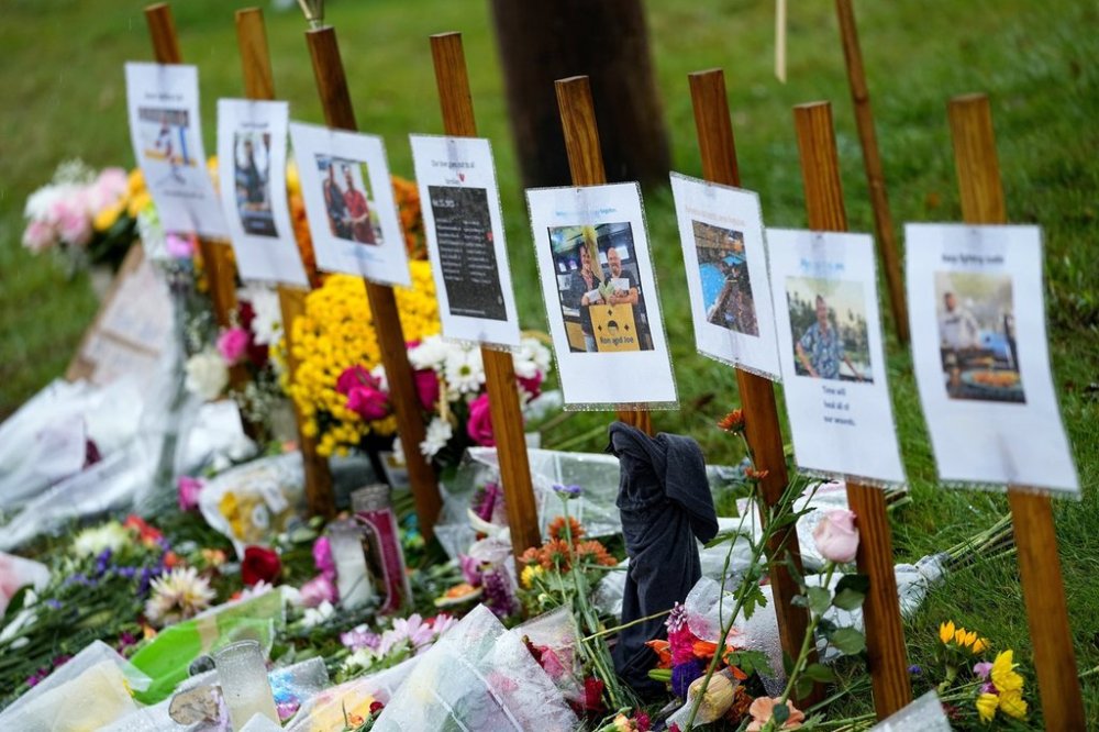 FILE — Rain soaked memorials for those who died in a mass shooting sit along the roadside by Schemengees Bar & Grille, Oct. 30, 2023, in Lewiston, Maine. (AP Photo/Matt York, File)
