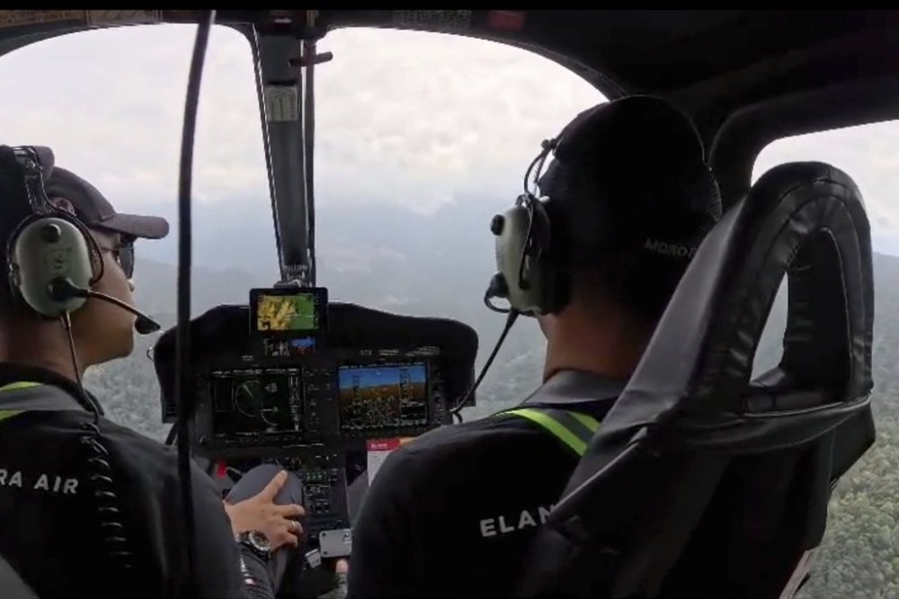 In this photo made from video released by Banjarmasin Search and Rescue Agency (BASARNAS Banjarmasin) on Tuesday, Sept. 2, 2025, pilots control their aircraft during the search operation for a helicopter that went missing over the forests of Borneo with a number of people on board, near Kotabaru, South Kalimantan, Indonesia. (BASARNAS Banjarmasin via AP)