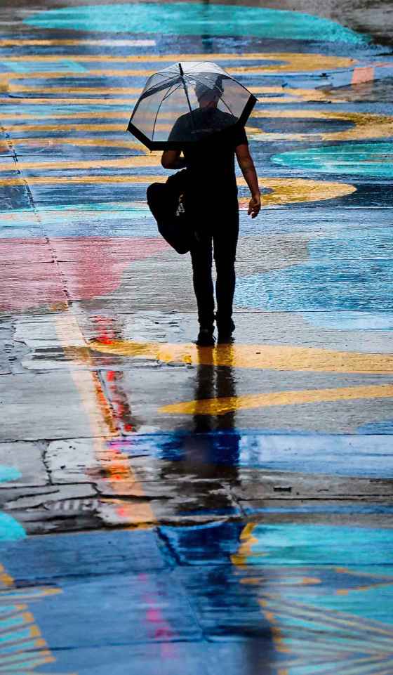 A person walks along newly painted Graham Avenue during a rain shower. (John Woods / Free Press)
