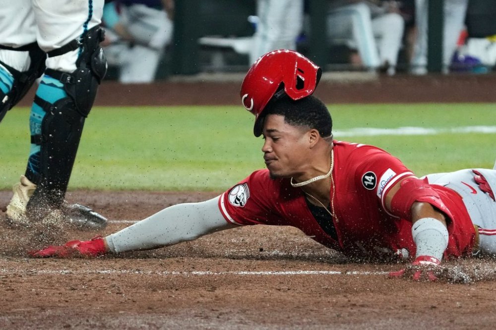 Cincinnati Reds' Noelvi Marte scores after hitting a triple and an error by Arizona Diamondbacks' Geraldo Perdomo in the sixth inning of a baseball game Sunday, Aug 24, 2025, in Phoenix. (AP Photo/Rick Scuteri)