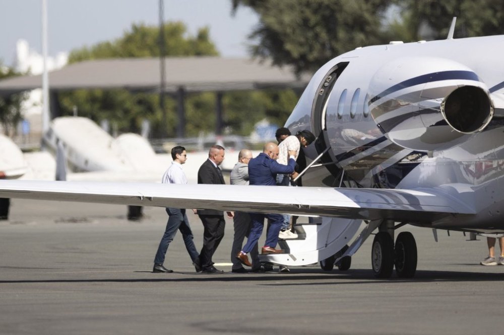 Harjinder Singh is escorted to an airplane by Florida Lt. Gov. Jay Collins and law enforcement on Thursday, Aug. 21, 2025, in Stockton, Calif. (AP Photo/Benjamin Fanjoy)