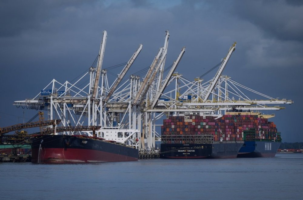 Coal is loaded onto the bulk carrier vessel Fosep at the Westshore coal export terminal at Roberts Bank as container ships are seen docked beneath gantry cranes at Deltaport, in Tsawwassen, B.C., on Monday, Sept. 9, 2024. THE CANADIAN PRESS/Darryl Dyck