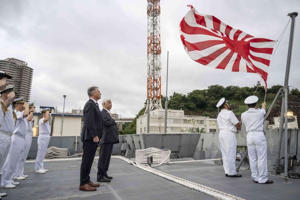 Australia's Defence Minister Richard Marles, centre left, and Japan's Defence Minister Gen Nakatani, centre right, take part in a ceremony ahead of a joint press announcement aboard the Japan Maritime Self-Defense Force (JMSDF) Mogami-class stealth frigate JS Mikuma at the JMSDF naval base in Yokosuka, Japan, Friday Sept. 5, 2025. (Yuichi Yamazaki/Pool Photo via AP)