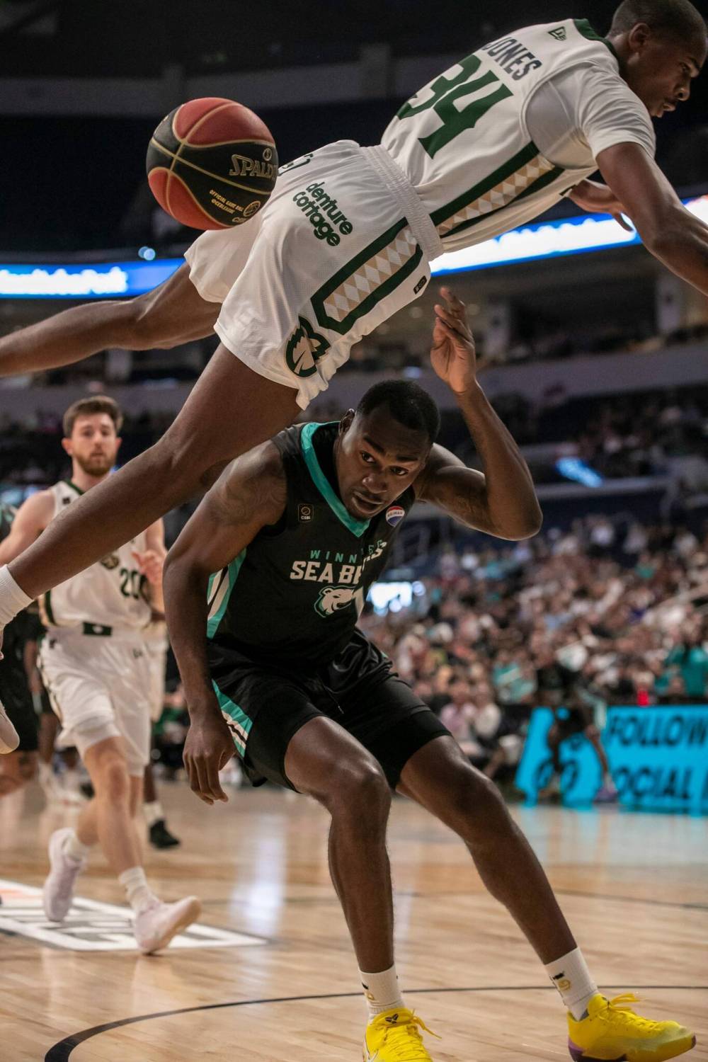 BROOK JONES / FREE PRESS
Sea Bears forward Jaylin Williams (No. 10) ducks while Rattlers guard Tevian Jones (No. 34) flies through the air during first quarter action.