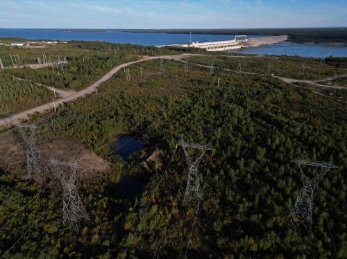 Tim Smith for The Narwhal
                                Manitoba Hydro power lines lead away from the Kettle Generating Station along the Nelson River overtop of forest just outside Gillam.