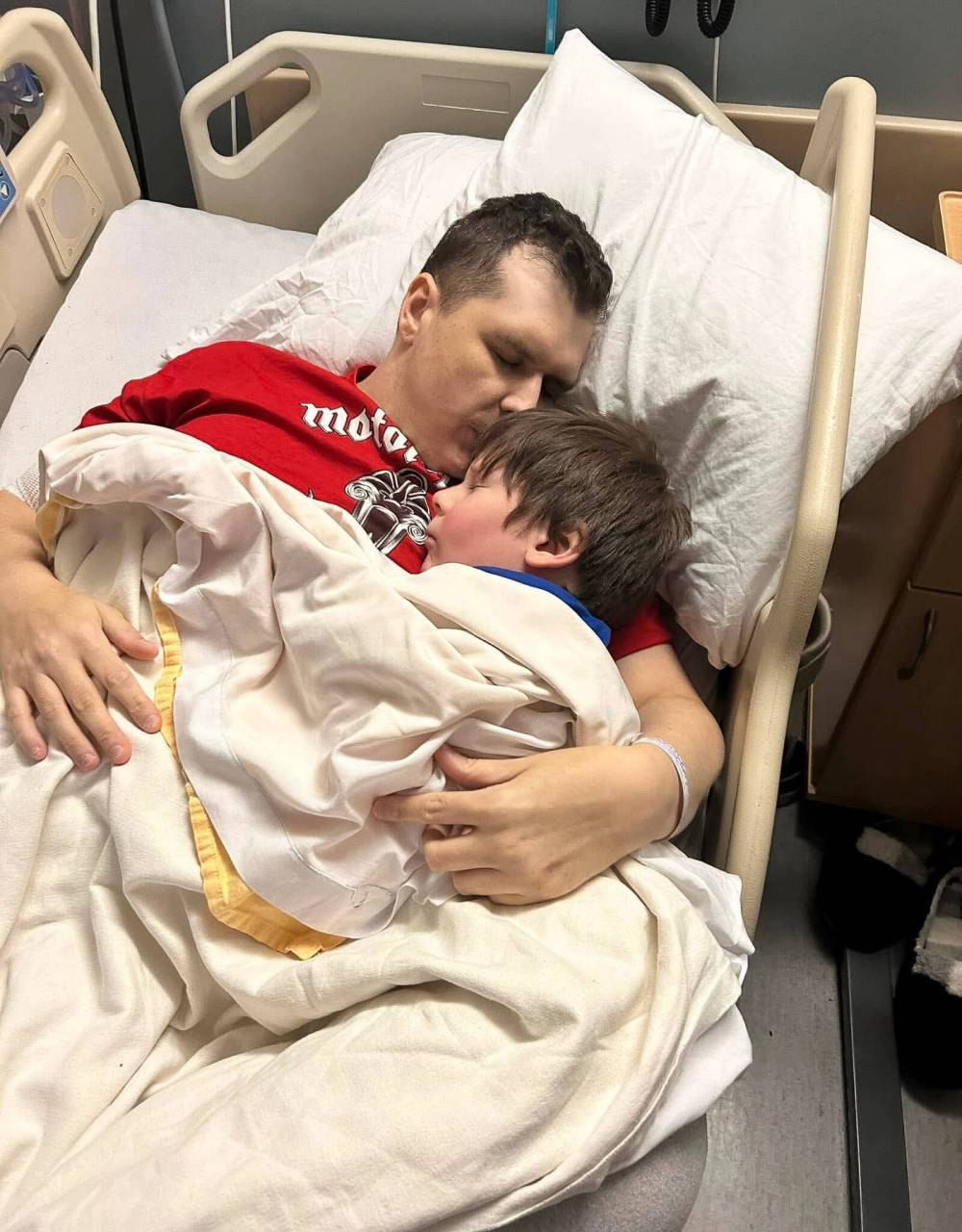 SUPPLIED
Sean sleeps with his dad Stephen Rockwell in the hospital.