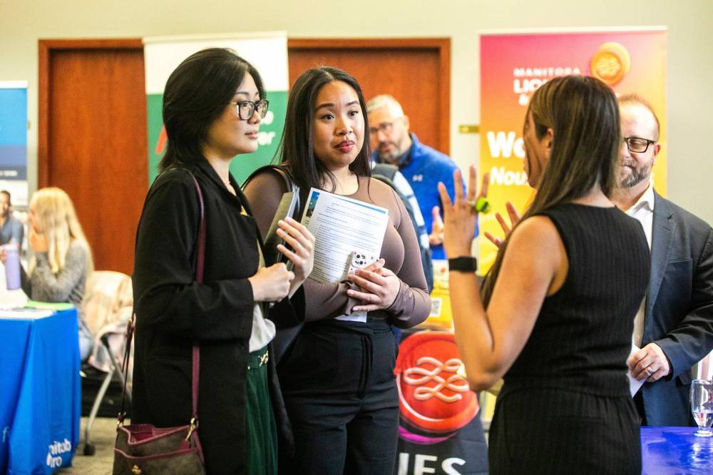MIKAELA MACKENZIE / FREE PRESS
Jana Catabona (left) and Isabelle Anglo chat with Tina Bedi of RBC at the women’s career fair in Winnipeg on Wednesday.
