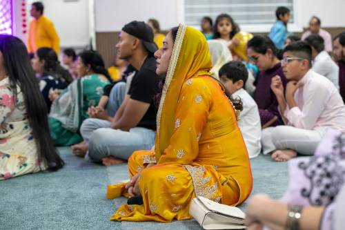 BROOK JONES / FREE PRESS
                                It is customary for people to wear traditional colourful attire and sit on the floor while in a prayer hall inside a Hindu temple.