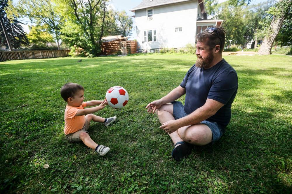 JOHN WOODS / FREE PRESS
Matt Salo and his son Alex play on a city-owned site at 546 Sherburn St. which has been earmarked as a location for a supportive housing unit for homeless and people requiring support services in Winnipeg. Salo is in favour of more housing but would like this particular site to remain a community green space.