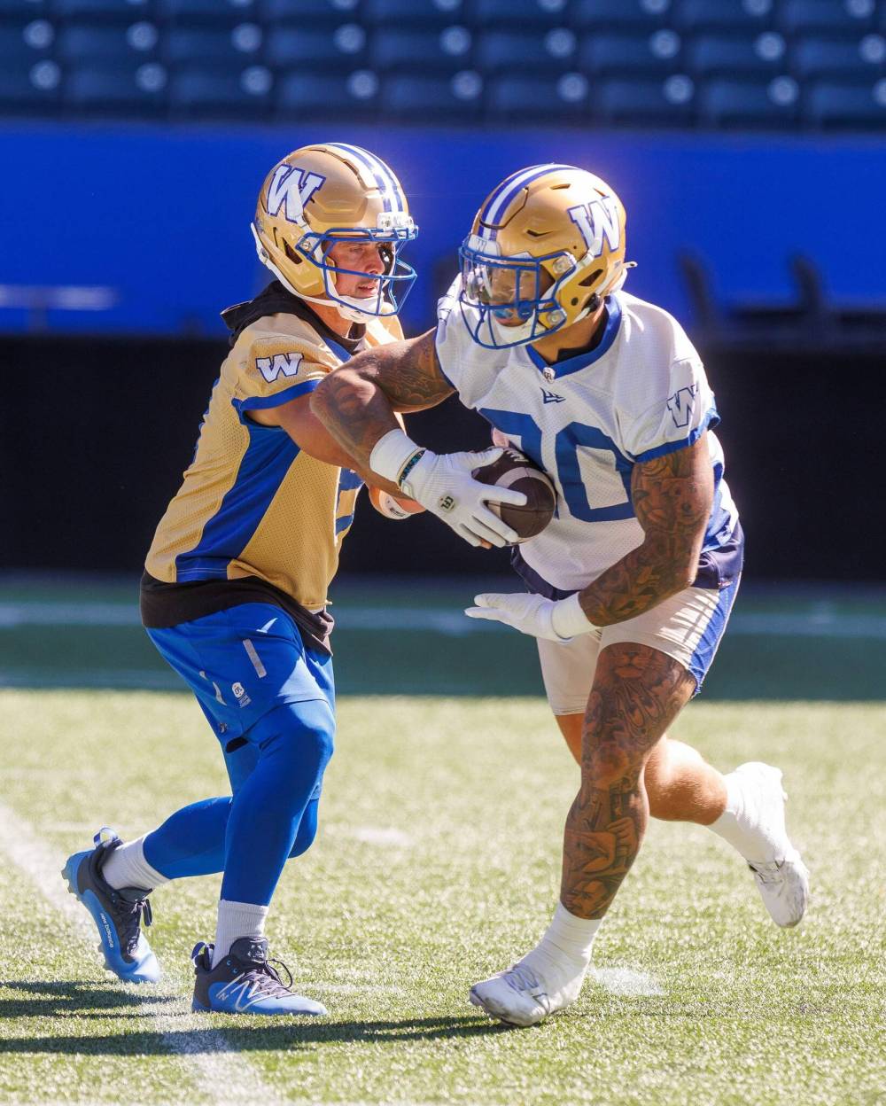 MIKE DEAL / FREE PRESS
                                Bombers QB Zach Collaros (left) hands the ball off to Brady Oliveira on Tuesday during practice.