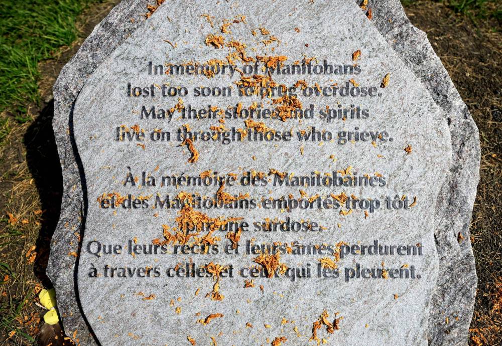 RUTH BONNEVILLE / FREE PRESS
The new memorial stone with tobacco sprinkled over its enscription.