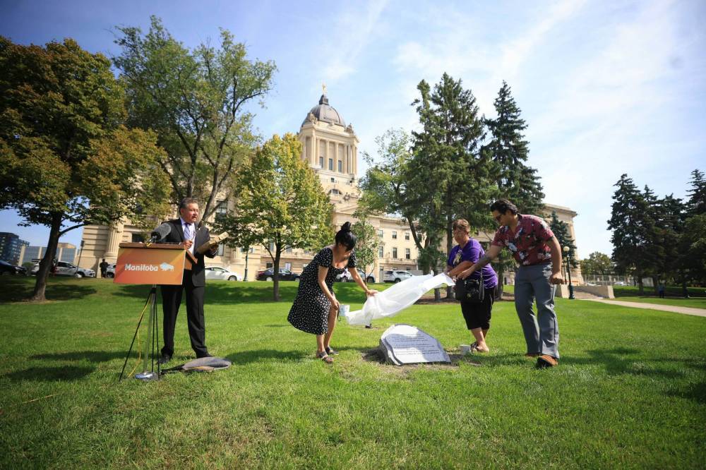 RUTH BONNEVILLE / FREE PRESS
Elder Mike Pierre sings and drums while the memorial stone is unveiled at ceremony Friday.