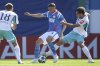 Hoffenheim's Leon Avdullahu, center, and Rostock's Kenan Fatkic, right, challenge for the ballduring the German soccer cup match between FC Hansa Rostock and TSG 1899 Hoffenheim in Rostock, Germany, Saturday, Aug. 16, 2025. (Christian Charisius/dpa via AP)