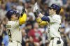 Milwaukee Brewers' Christian Yelich, right, high-fives with William Contreras after Yelich hit a two-run home run against the Pittsburgh Pirates during the fifth inning of a baseball game, Tuesday, Aug.12, 2025, in Milwaukee. (AP Photo/Jeffrey Phelps)